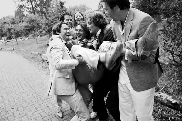 Groom being carried by groomsmen