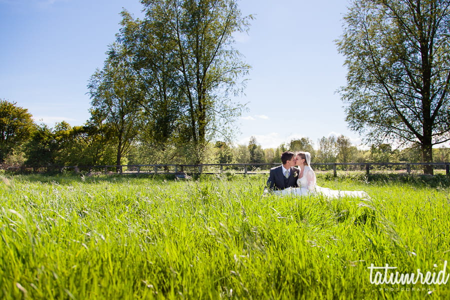 Bride and groom sitting in a field