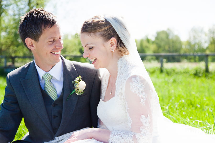 Bride and groom sitting in a field