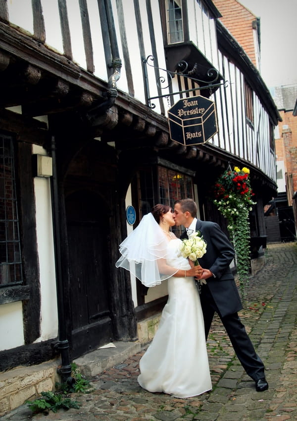 Bride and groom kissing down old street - Picture by Twirly Girl Photography