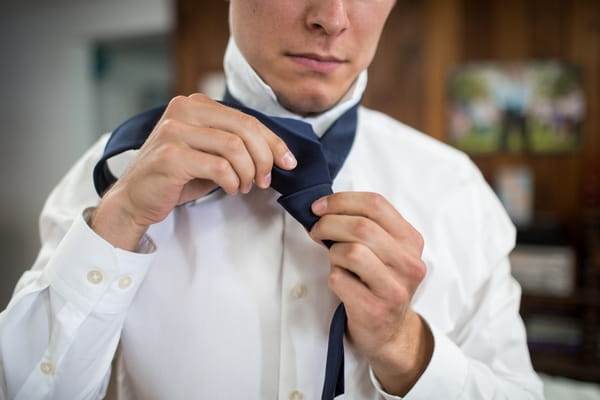 Groom doing up tie