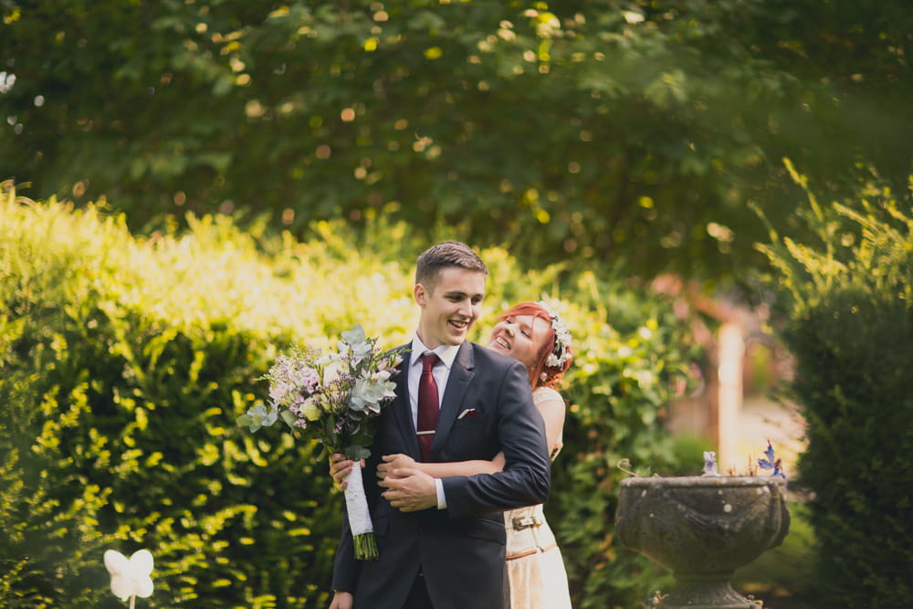 Bride hugging groom from behind