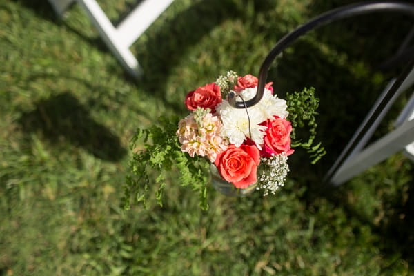 Flowers hanging on end of wedding seating row