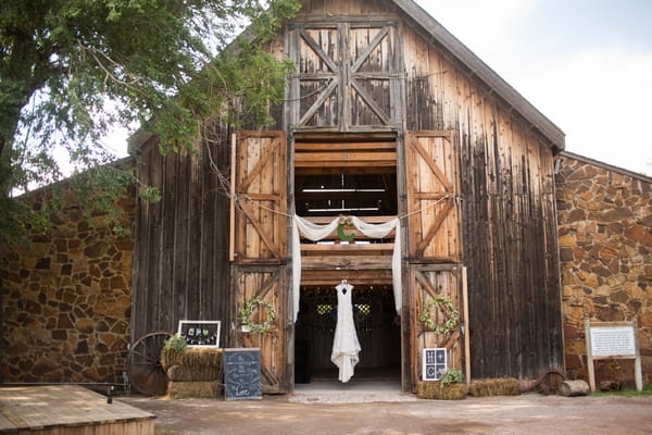 Wedding dress hanging in entrance to barn