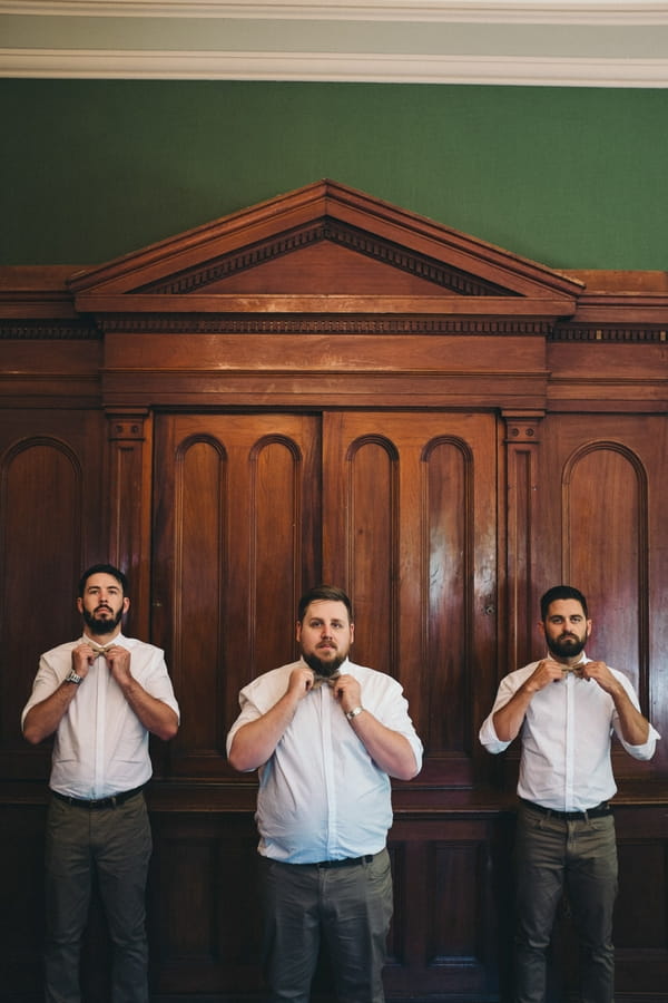 Groomsmen adjusting bow ties