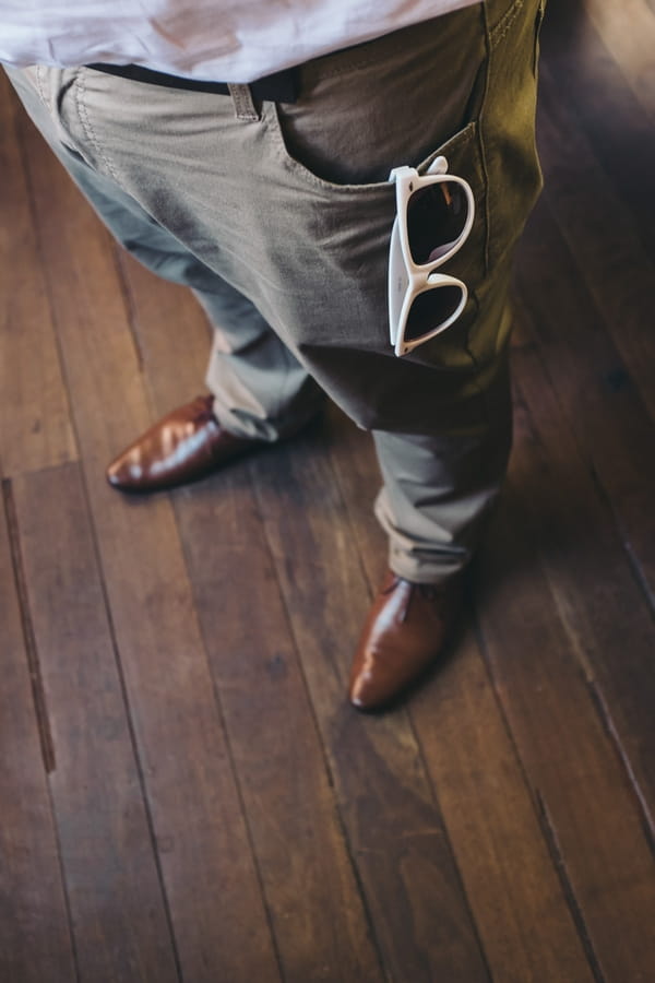 Sunglasses hanging from groom's pocket