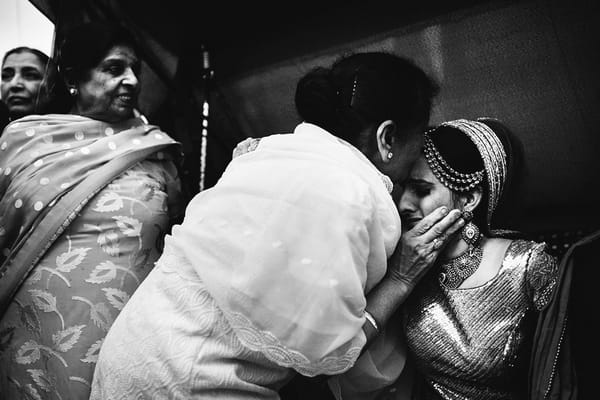 Woman kissing bride on head - Picture by Martin Makowski Photography