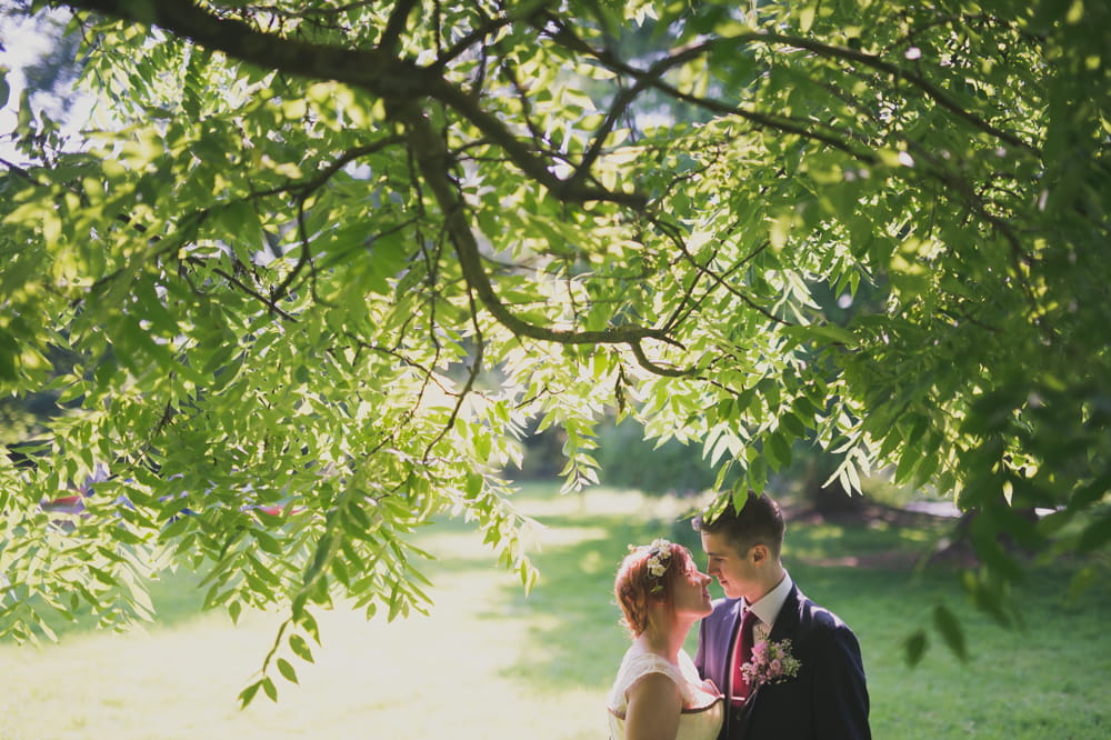 Bride and groom under tree