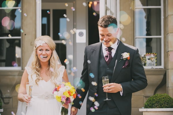 Bride and groom walking through bubbles