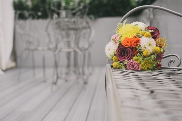 Bridal bouquet on end of bench