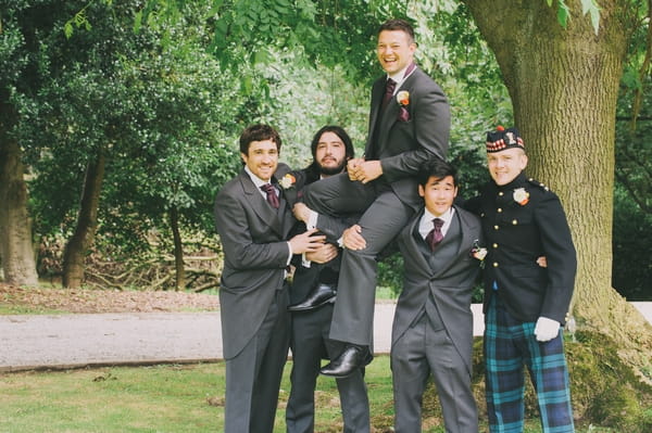 Groomsmen lifting up groom