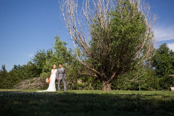 Bride and groom by tree