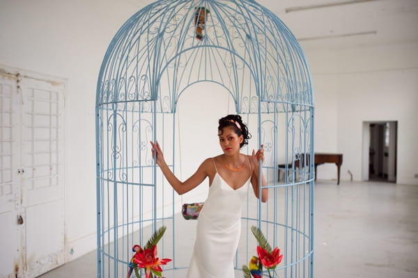 Bride standing in large bird cage