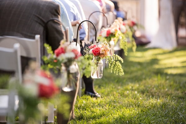 Jars of flowers on end of seating rows