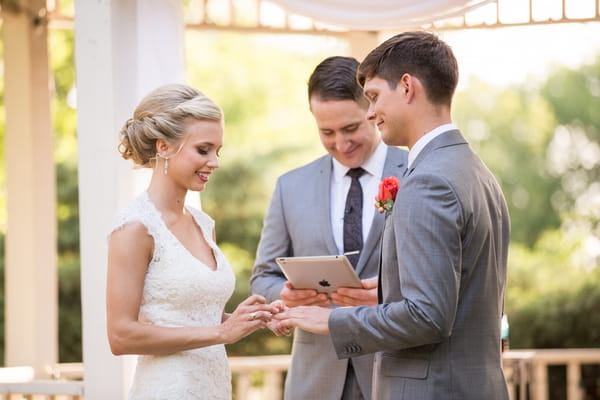 Bride putting ring on groom's finger