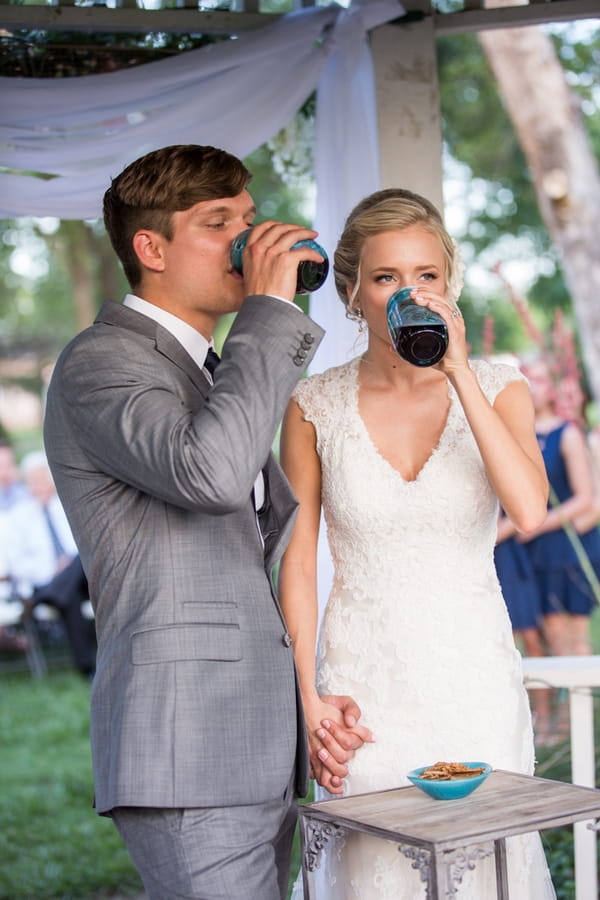 Bride and groom drinking from jars