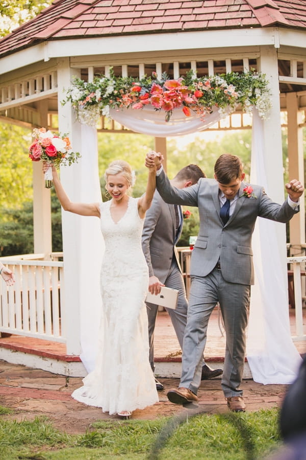 Bride and groom with arms in air