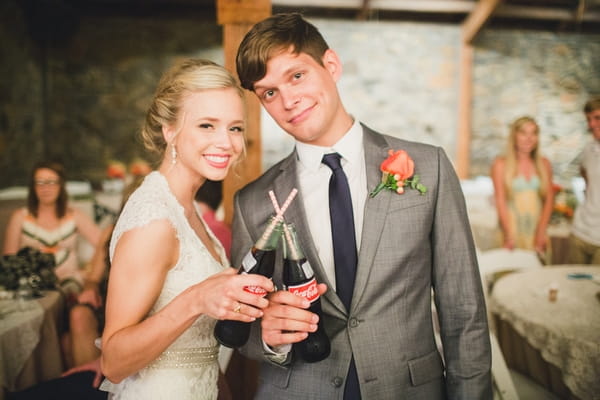 Bride and groom with bottles of coke