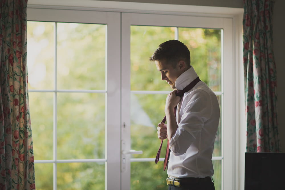 Groom doing up tie