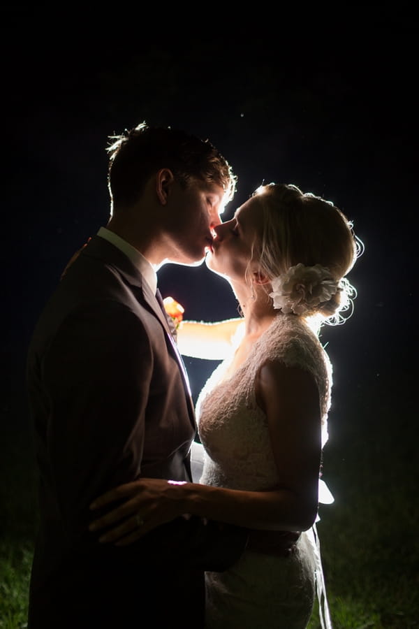 Bride and groom kiss in dark