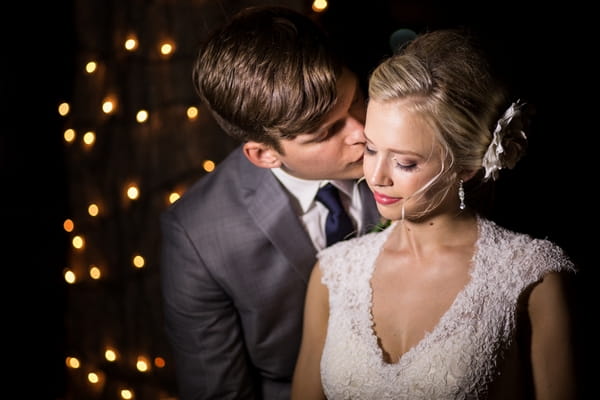 Groom kissing bride on cheek