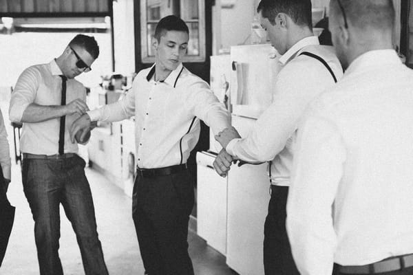 Groomsmen helping groom get ready