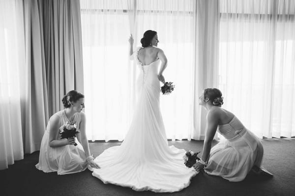 Bride having dress adjusted