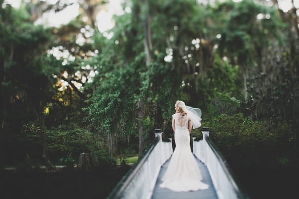 Bride walking over bridge