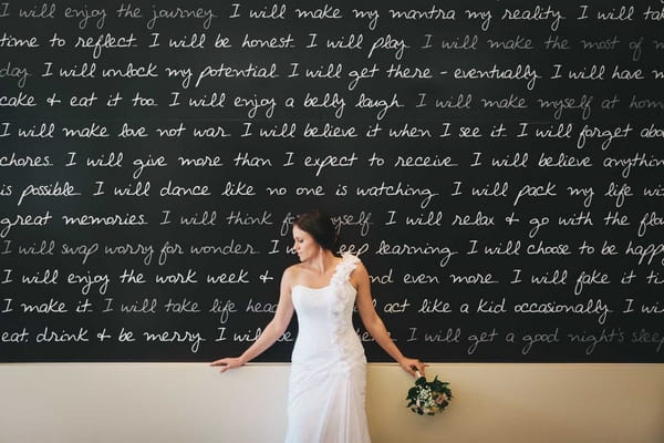 Bride standing in front of classroom chalkboard