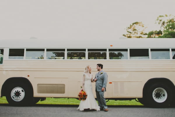 Bride and groom in front of vintage bus