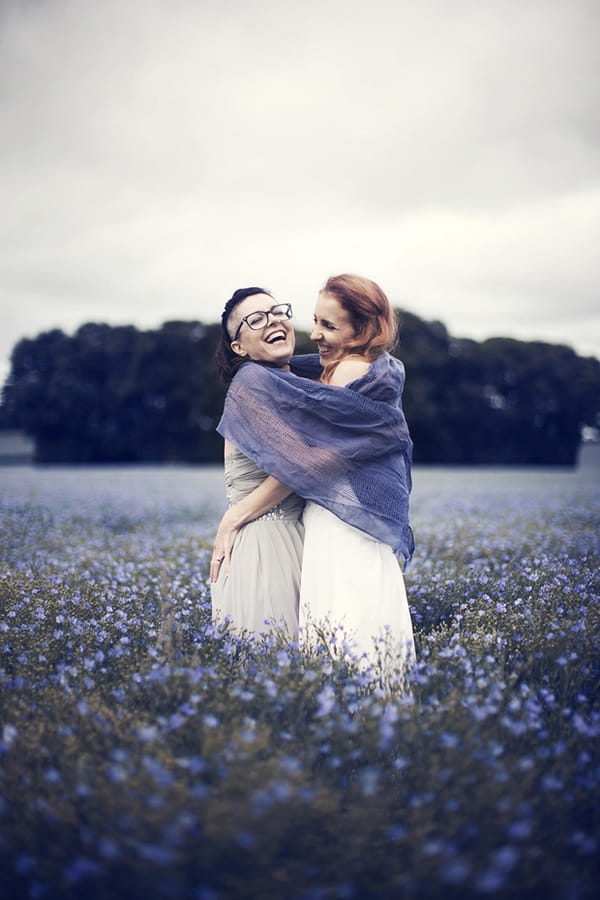 Brides laughing in field