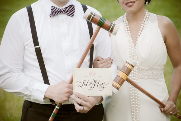 Bride and groom holding Let's Play sign