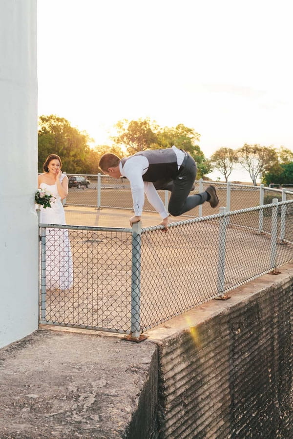 Groom jumping fence