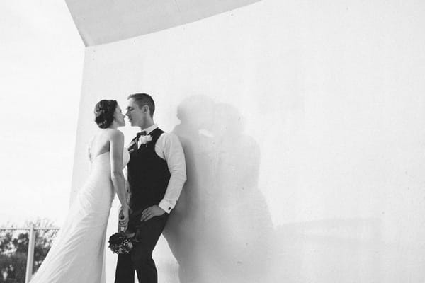 Bride and groom against wall