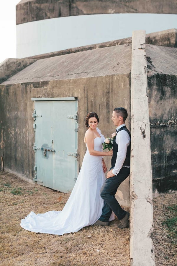 Bride and groom against post