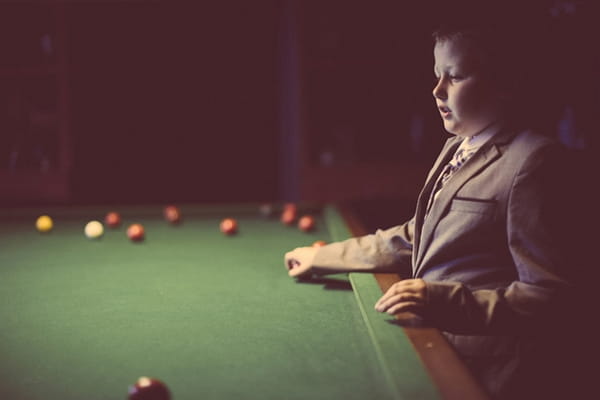 Boy standing next to snooker table