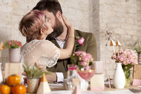 Groom kissing bride on cheek