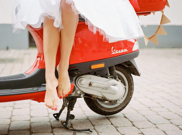 Bride's legs on red Vespa