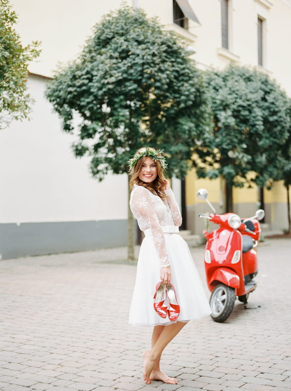 Bride holding red shoes