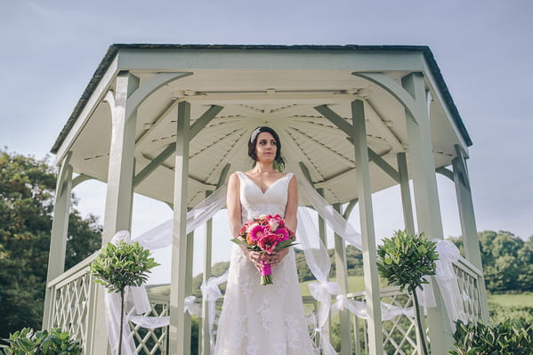 Bride standing holding bouquet at Pengenna Manor