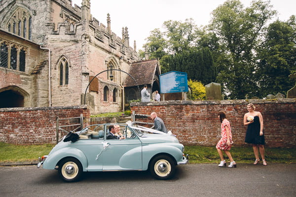 Bride arriving at church in blue Morris Minor