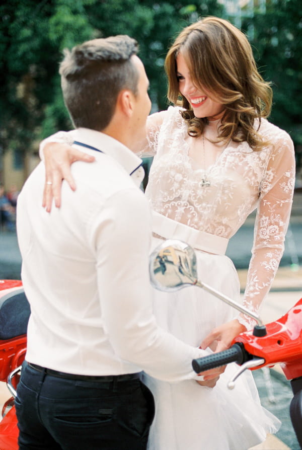 Bride and groom on red Vespa