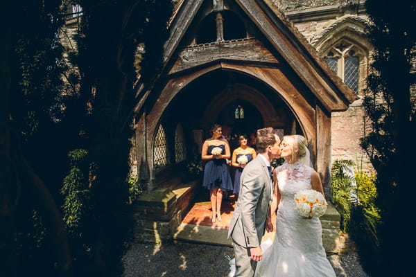 Bride and groom kiss outside church