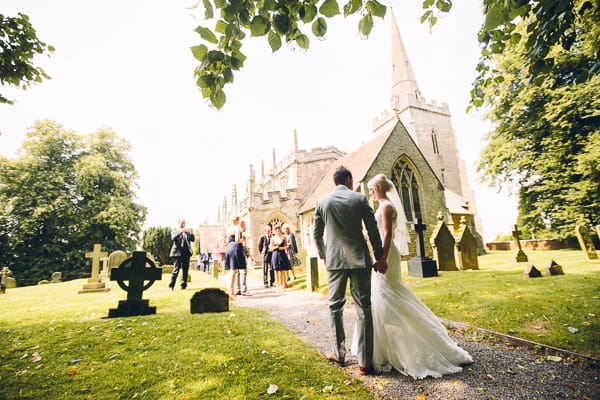 Bride and groom walking down church path