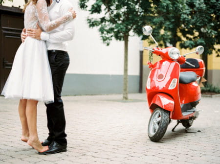 Couple next to red Vespa