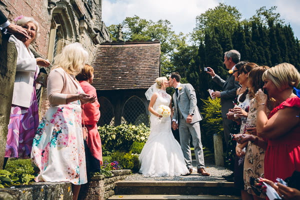 Bride and groom kiss on church steps