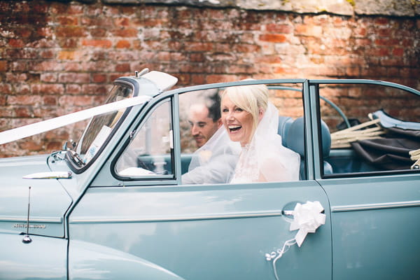 Bride and groom in blue Morris Minor wedding car