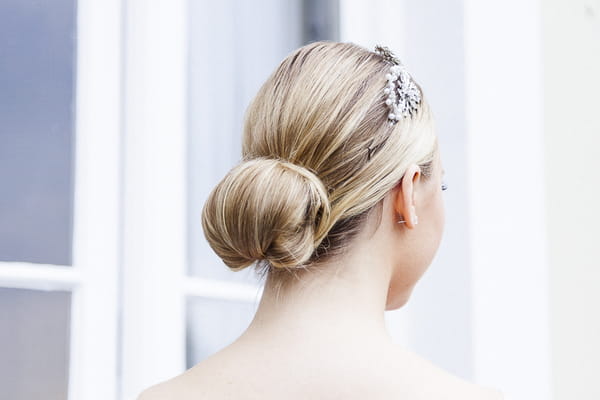 Bridesmaid with chignon bun hairstyle and hair accessory