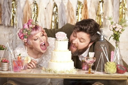 Bride and groom pretending to eat wedding cake