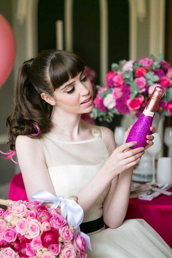 Bride looking at purple bottle